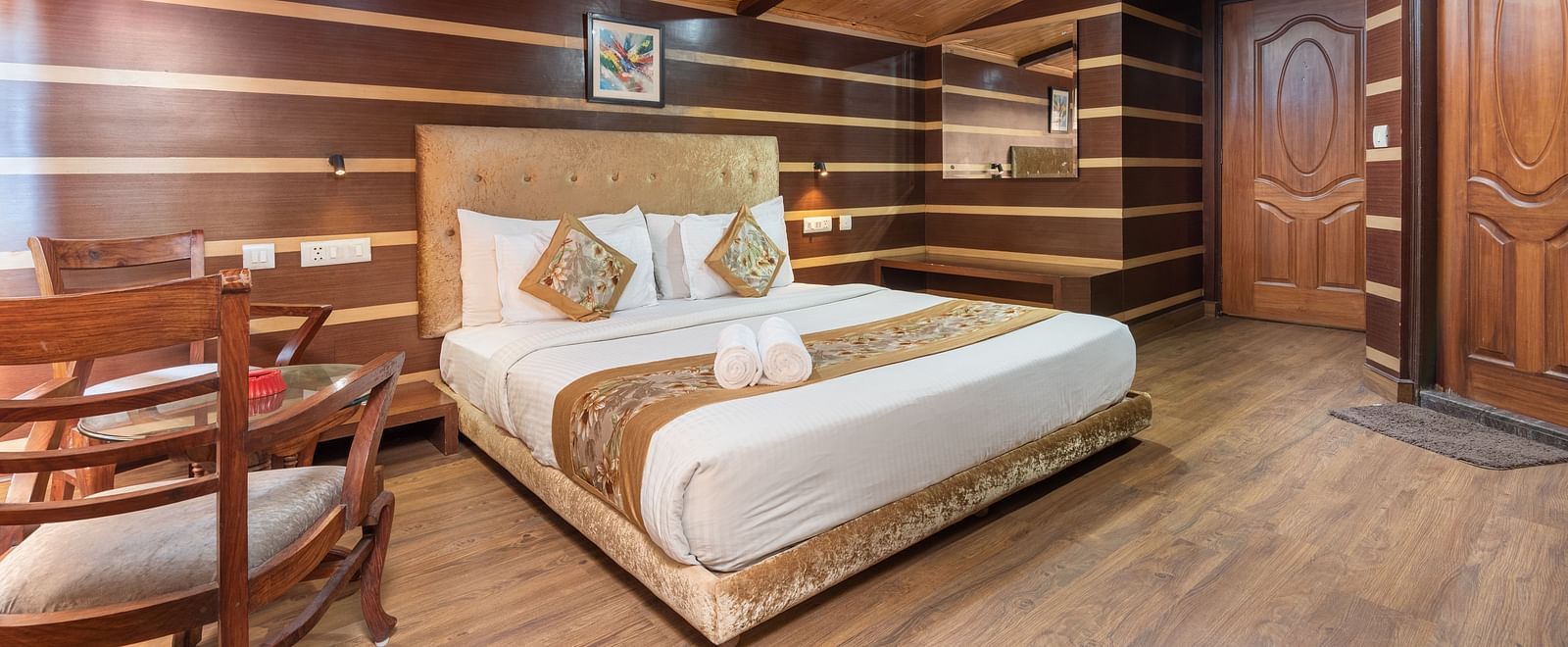 Super Deluxe Room with a king size bed and wooden finished flooring at DLS Hotels The Rock Castle.